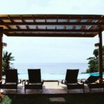 photo of four loungers under gazebo facing swimming pool