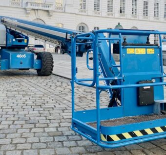 a large blue crane sitting in front of a white building