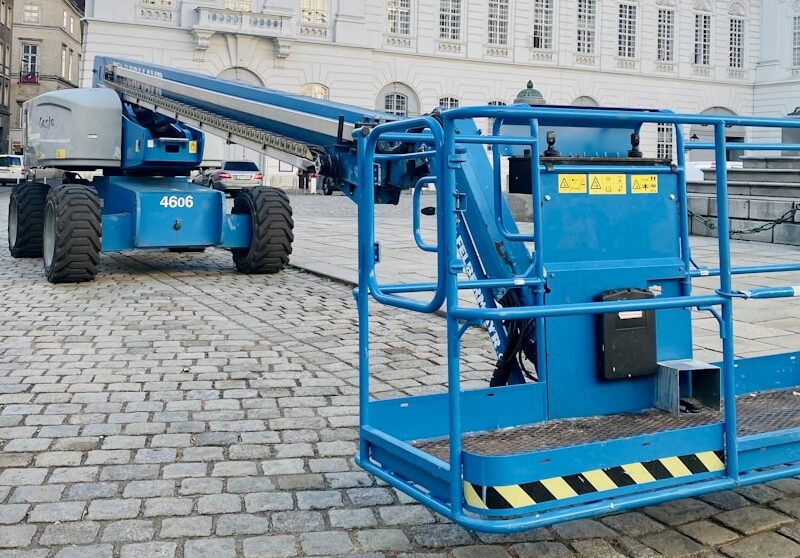 a large blue crane sitting in front of a white building