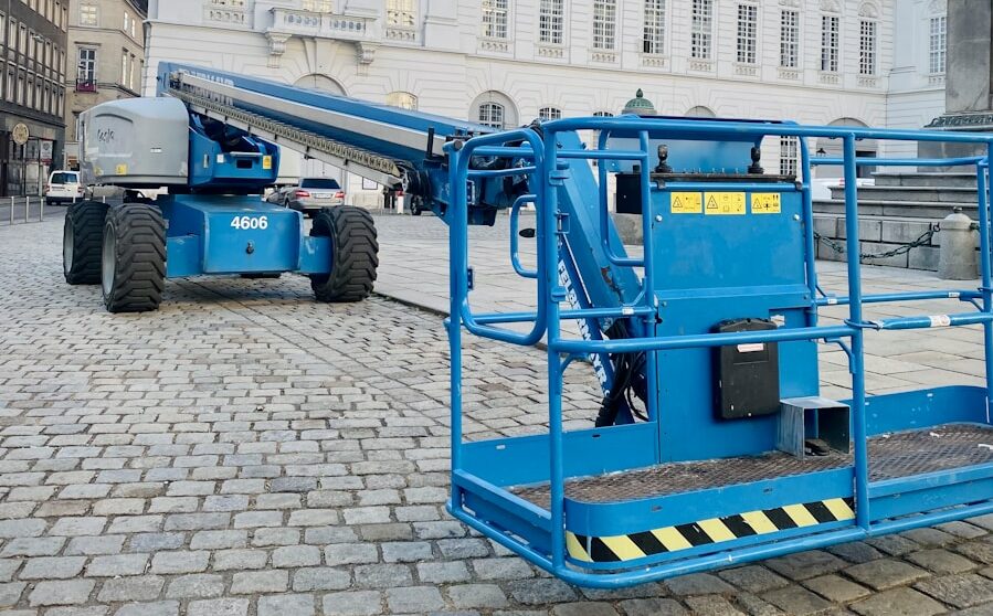 a large blue crane sitting in front of a white building